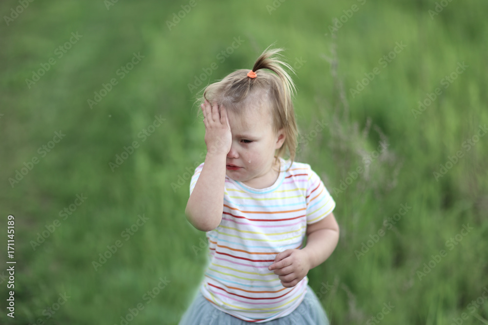 Fototapeta premium Toddler girl is crying and rubbing his eyes