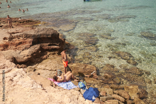 Platges de Comte, Ibiza, Balearic islands - August 29, 2014 : Tourists sunbathing in Platges de Comte photo