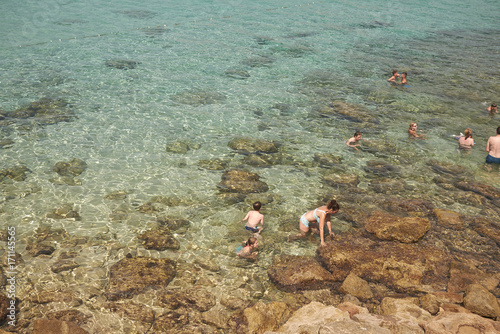 Platges de Comte, Ibiza, Balearic islands - August 29, 2014 : Tourists sunbathing in Platges de Comte photo