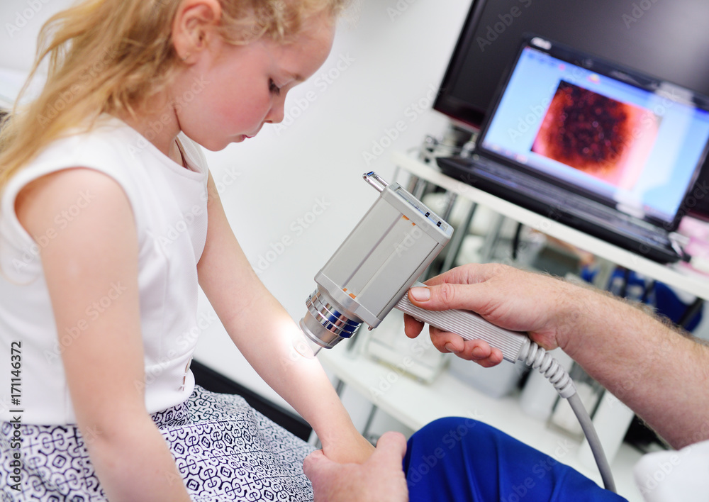 Fototapeta premium the doctor examines the special medical device moles child