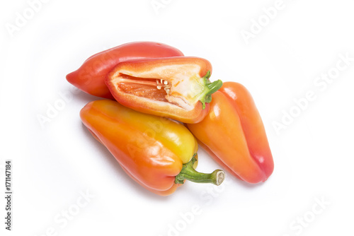 three sweet peppers and a half of sweet pepper on a white background