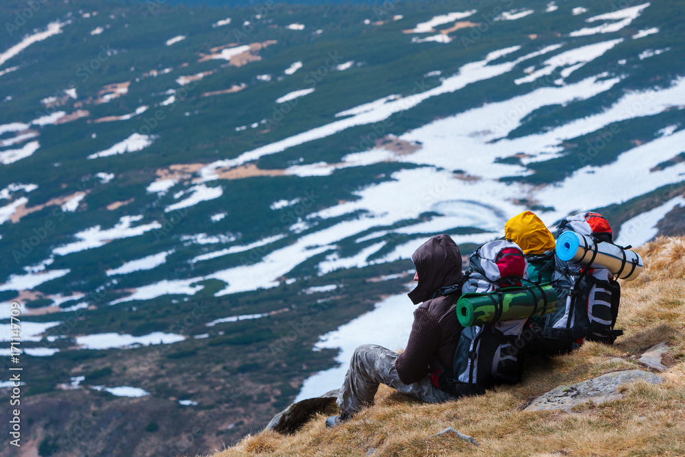 Hiking tourists with backpacks and mats in the mountains. Climb to the top mountains. Concept theme: nature, weather, climbing, tourism, extreme, healthy lifestyle, adventures. Unrecognizable faces.