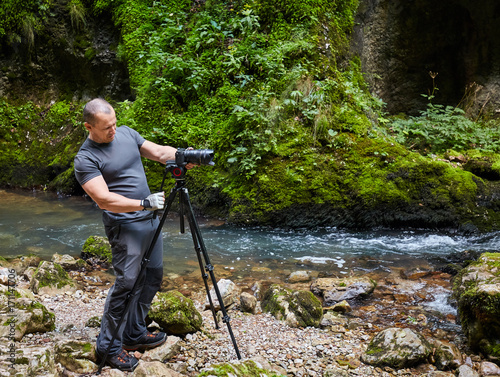 Professional nature photographer with camera on tripod