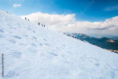 Tourists climbs for camping to the snow-capped mountain top. Concept theme: nature, weather, climbing, tourism, extreme, healthy lifestyle, adventures. Unrecognizable faces. © Sodel Vladyslav