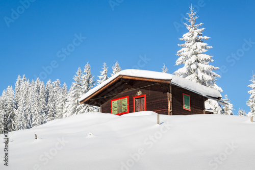 Wooden hunting cabin in winter landscape