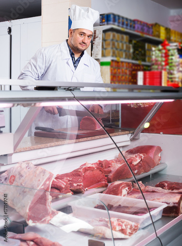 Butcher cutting fresh lamb meat