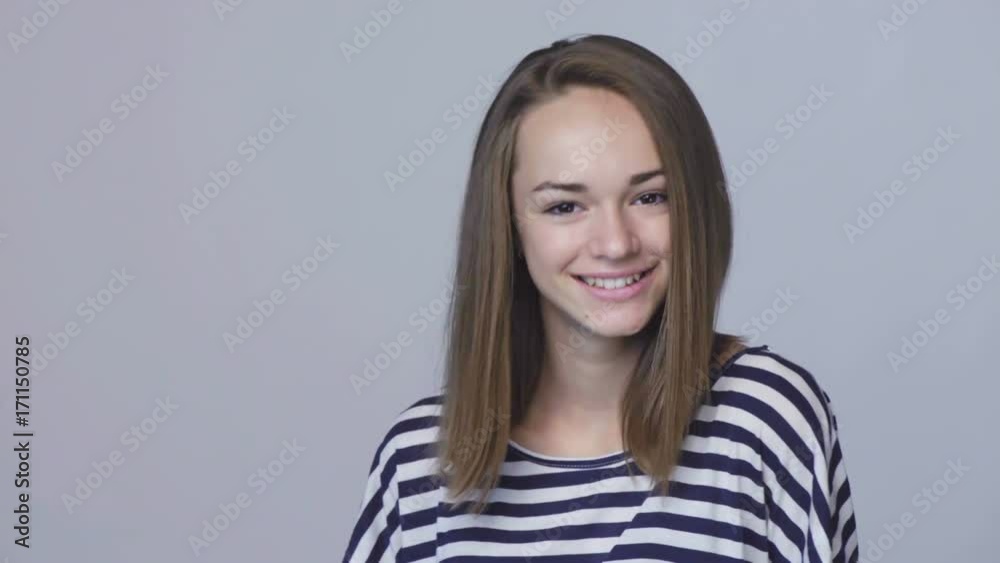 Closeup portrait of teen girl in casual clothing looking at camera playful smiling shrugging her shoulders, gesturing thumb up at the end Closeup portrait of teen girl in casual clothing looking at camera playful smiling shrugging her shoulders, gesturing thumb up at the end