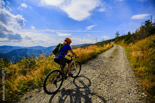 Cycling women riding on bike in autumn mountains forest landscape. Woman cycling MTB flow trail track. Outdoor sport activity.