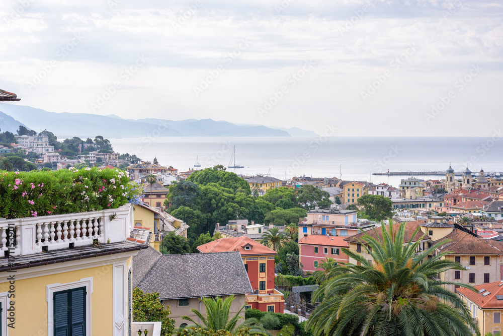 Obraz premium Morning view from above to cloudy day in Santa Margherita Ligure city and sea in Italy. Balcony full of flowers.