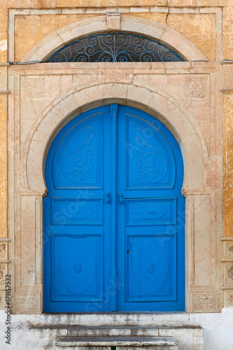 Tunisian eastern courtyard houses with white walls and blue windows doors © themanwhophoto