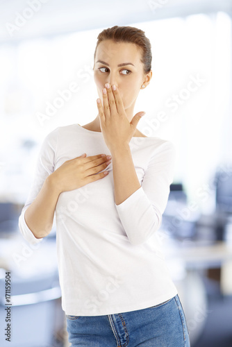 What happened  Portrait of a worried young woman standing with her hand befor her mouth