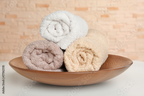 Plate with soft rolled towels and on table