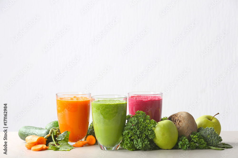 Fresh juices in glasses and ingredients on white background Fresh juices in glasses and ingredients on white background
