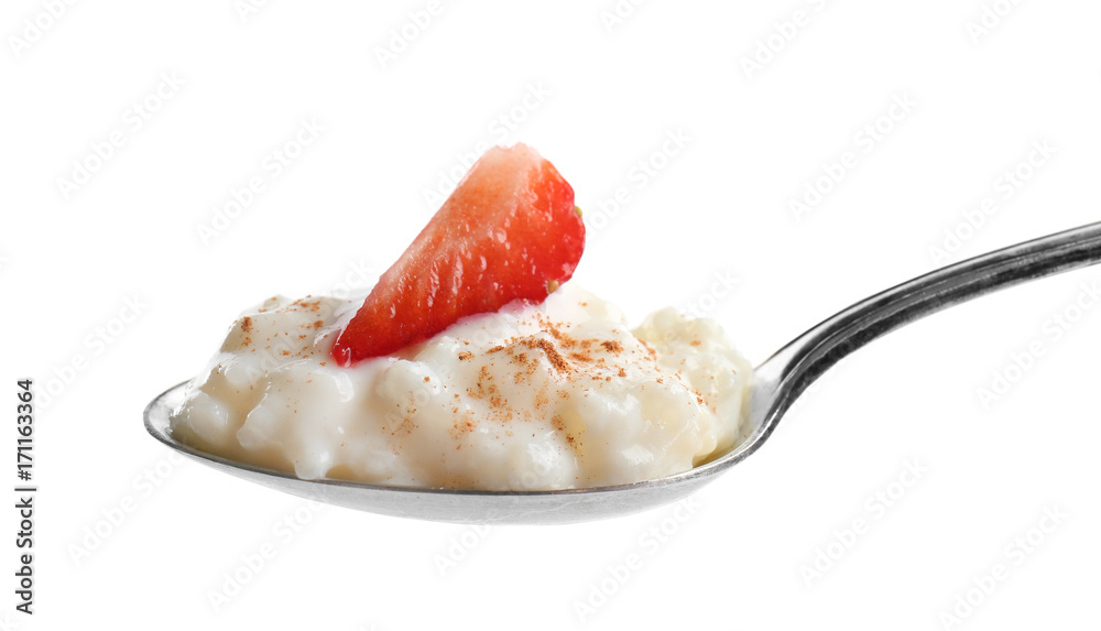 Spoon with creamy rice pudding and strawberry on white background Spoon with creamy rice pudding and strawberry on white background