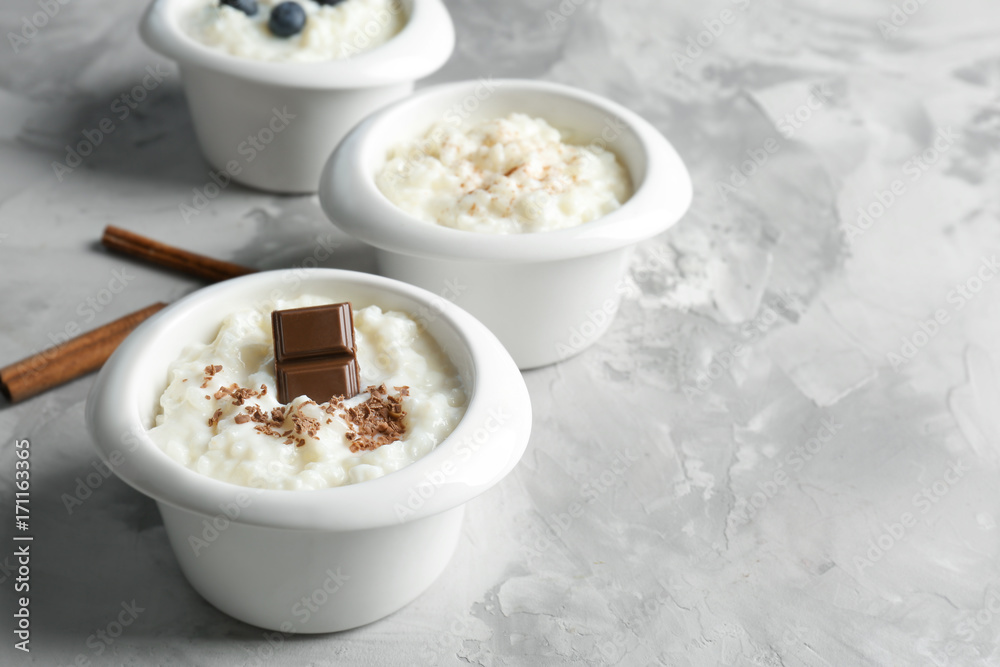Different creamy rice puddings in bowls on table Different creamy rice puddings in bowls on table