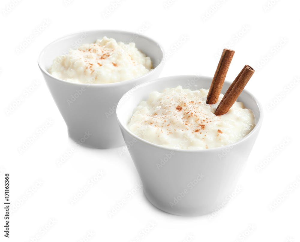 Creamy rice pudding with cinnamon powder in bowls on white background Creamy rice pudding with cinnamon powder in bowls on white background