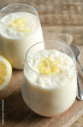 Creamy rice pudding with lemon on table, closeup