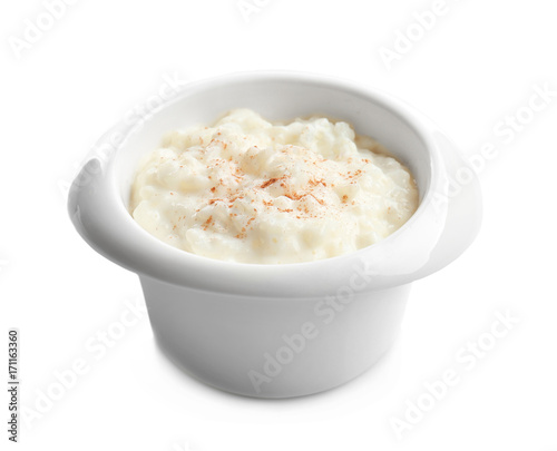 Creamy rice pudding with cinnamon powder in bowl on white background
