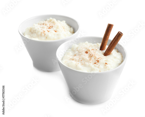 Creamy rice pudding with cinnamon powder in bowls on white background