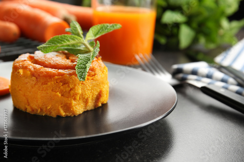 Plate with tasty carrot souffle on table, closeup