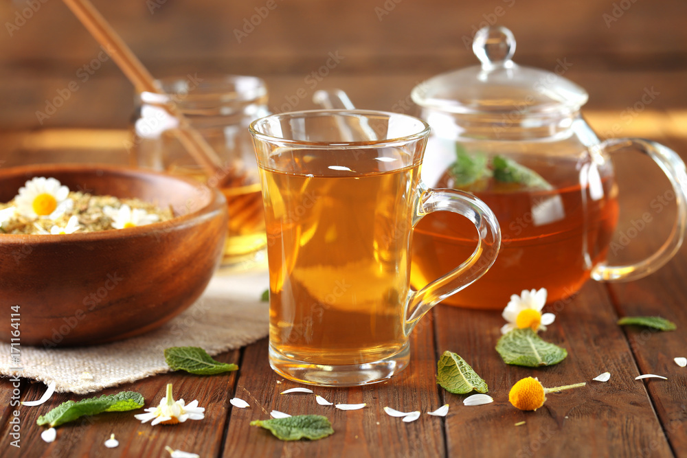 Composition with cup of chamomile tea on wooden table Composition with cup of chamomile tea on wooden table
