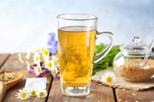 Cup of herbal tea with chamomile flowers on wooden table