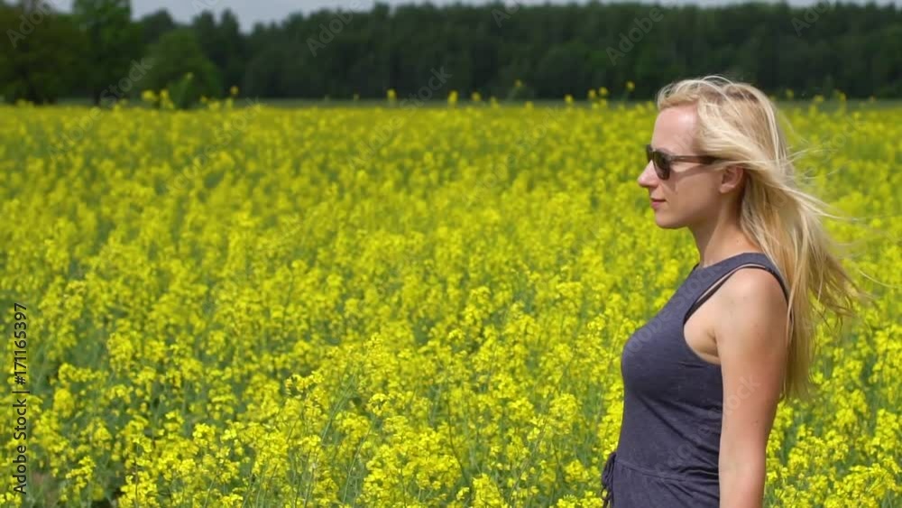 young blonde woman posing in beautiful rapeseed field young blonde woman posing in beautiful rapeseed field