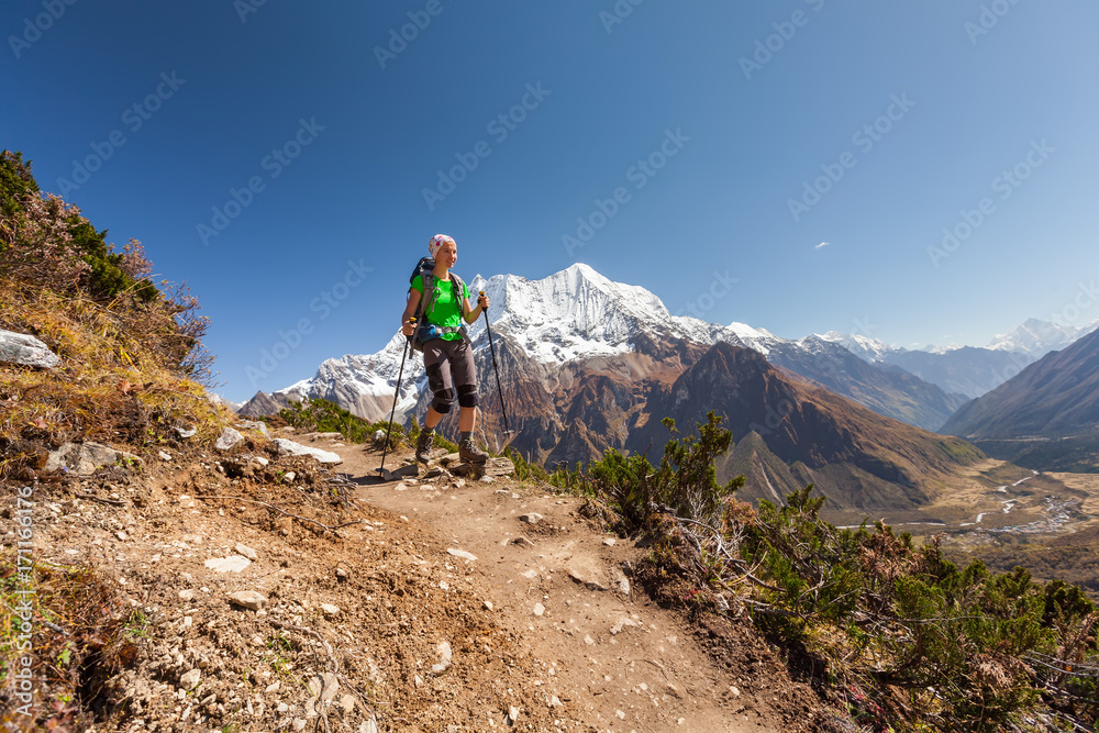 Hiker is climbig to Manaslu base camp in highlands of Himalayas on Manaslu circuit Hiker is climbig to Manaslu base camp in highlands of Himalayas on Manaslu circuit