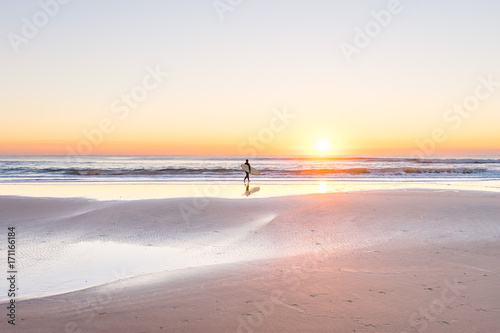 Fototapeta Naklejka Na Ścianę i Meble -  Surfer on the beach at sunrise