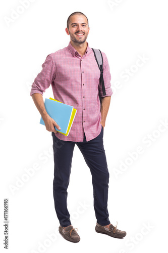 Smiling student standing with textbooks and backpack on white background