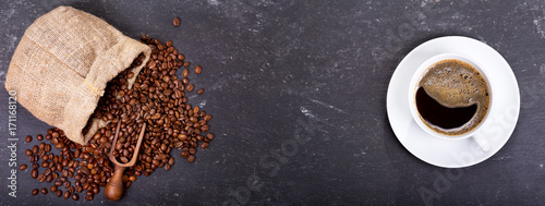 cup of coffee with beans on dark background