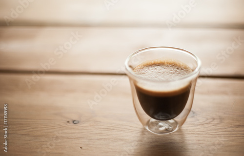 Fototapeta Naklejka Na Ścianę i Meble -  A single shot of espresso in a double wall glass on a wooden table