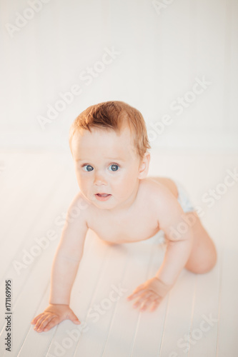 side view of pretty crawling baby on bed photo