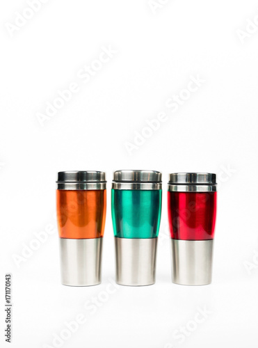 Orange, green and red thermos bottle on white background with copy space