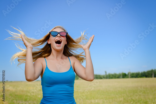 Joyful excited lovely attractive woman is watching 3 D movie. Excitement beauty young lady over light background. Funky enjoyment, surprised amazing experience. People having fun leisure lifestyle photo