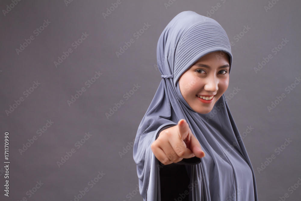 happy smiling confident muslim woman pointing at you, with hijab or head scarf happy smiling confident muslim woman pointing at you, with hijab or head scarf
