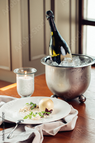 Sweet dessert with ice cream ball, sugar candy, fruit and mint on white plate photo