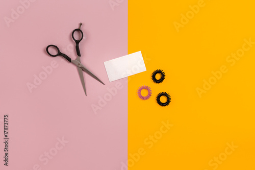 Scissors on the color pink, yellow paper background. Top view. photo