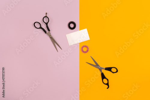 Scissors on the color pink, yellow paper background. Top view. photo