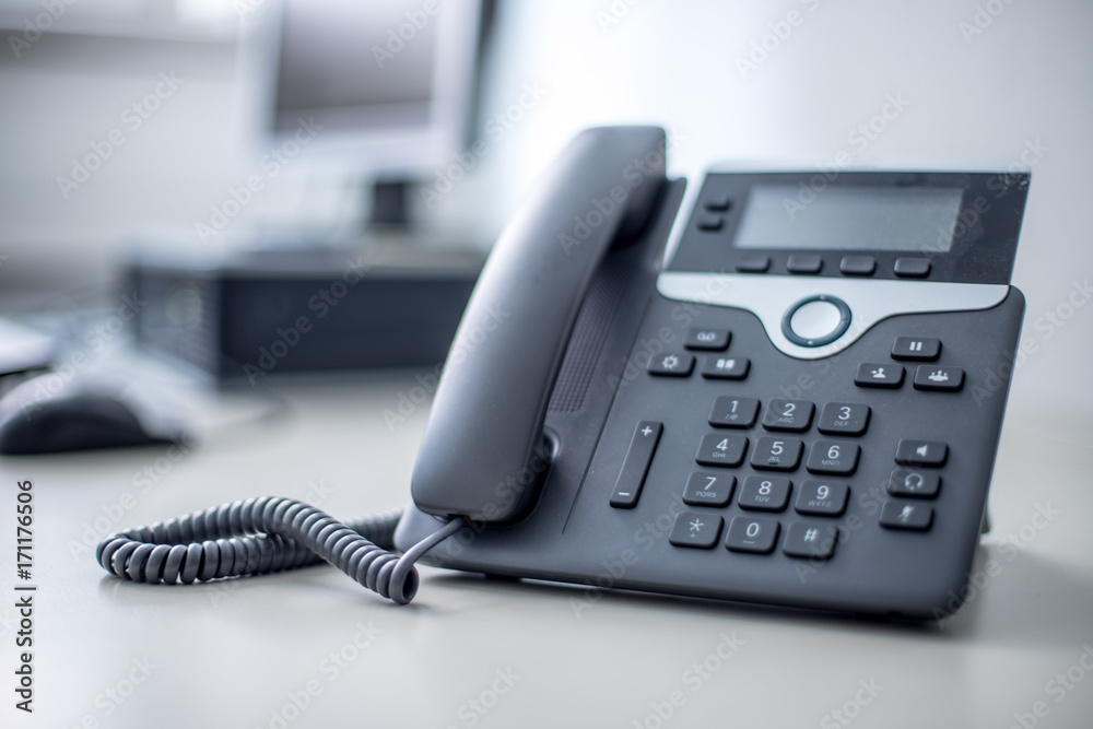 Arbeitsplatz mit Telefon, Computer im Hintergrund Arbeitsplatz mit Telefon, Computer im Hintergrund