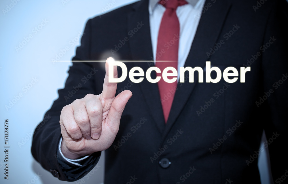 Businessman pressing button on virtual screen December button - concept Businessman pressing button on virtual screen December button - concept