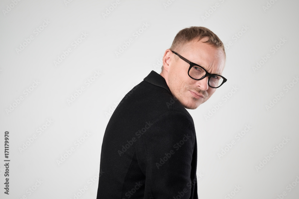 Smiling young man in black clothes standing against white background