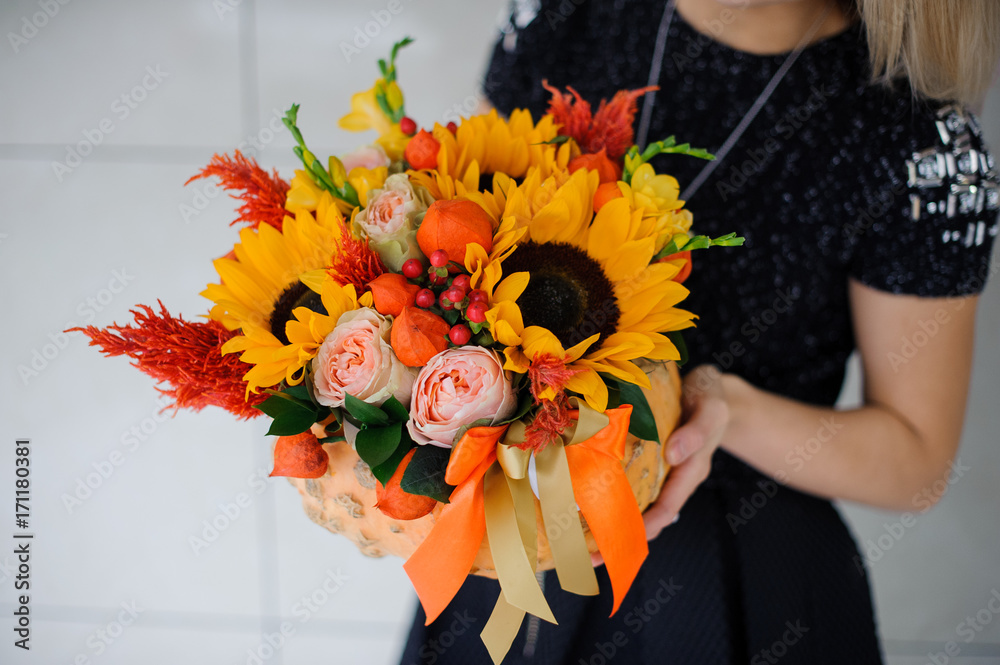 Fototapeta premium Young girl holding a bouquet of sunflowers
