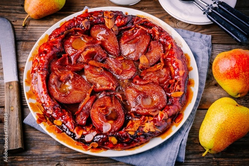 Tarte tatin with caramelized pears, orange peel and almonds photo