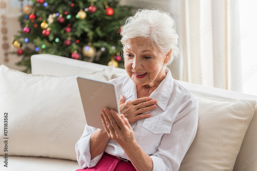 Elegant old woman is reading news using modern technologies Elegant old woman is reading news using modern technologies