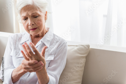 Elderly lady is enduring strong ache photo