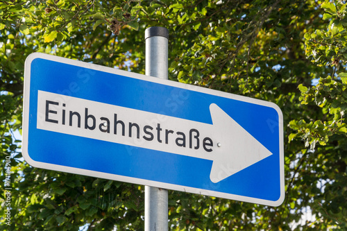 German One Way street sign with trees in the background