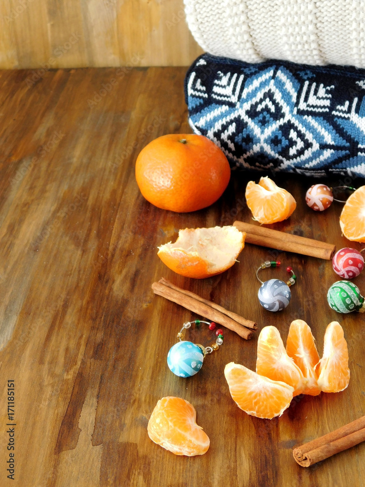 Mandarins, Christmas balls and knitted sweaters on a wooden table. Christmas composition. Copy place
