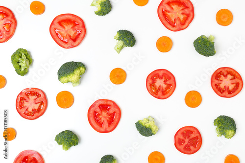 Fototapeta Naklejka Na Ścianę i Meble -  Colorful pattern of tomatoes,  broccoli, carrots on a white background. Top view of sliced seasonal vegetables. The concept of a healthy diet