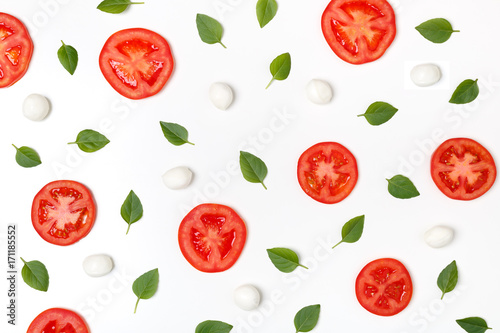 Colorful pattern of tomatoes, basil and mozzarella on a white background. Top view of a classic combination of tomatoes and mozzarella cheese. The concept of a healthy diet